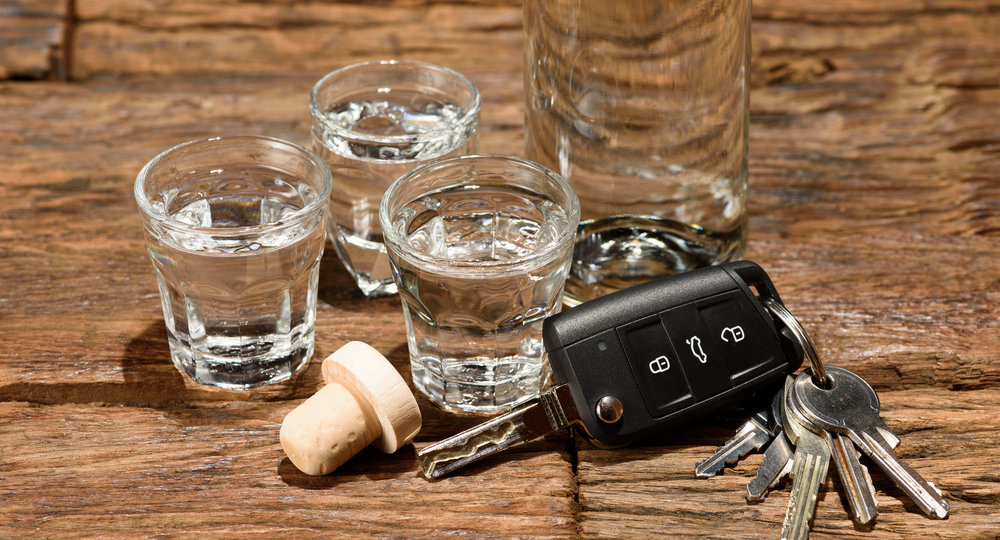 Shot glasses and a car key on an old wooden table
